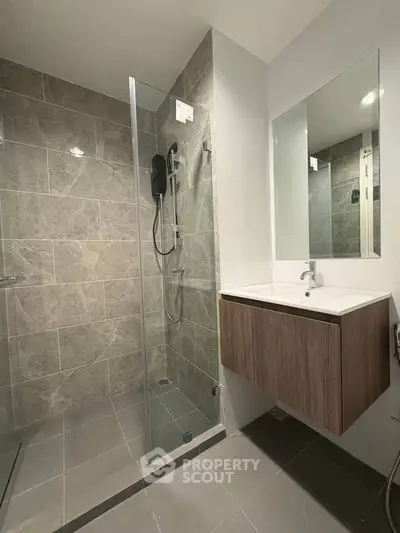 Modern bathroom with sleek glass shower and stylish vanity in contemporary home.