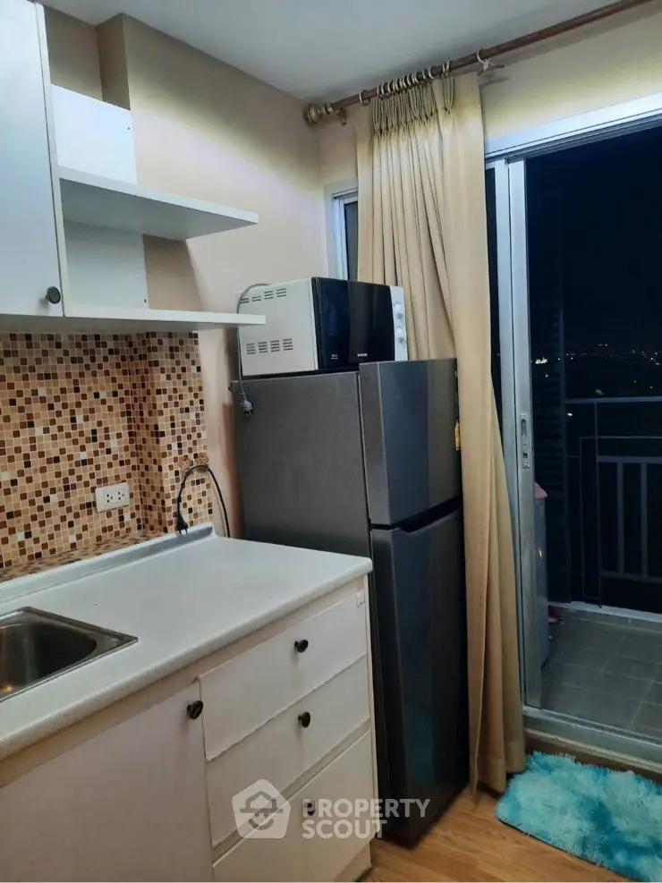 Cozy kitchen with balcony access and modern appliances in a stylish apartment.