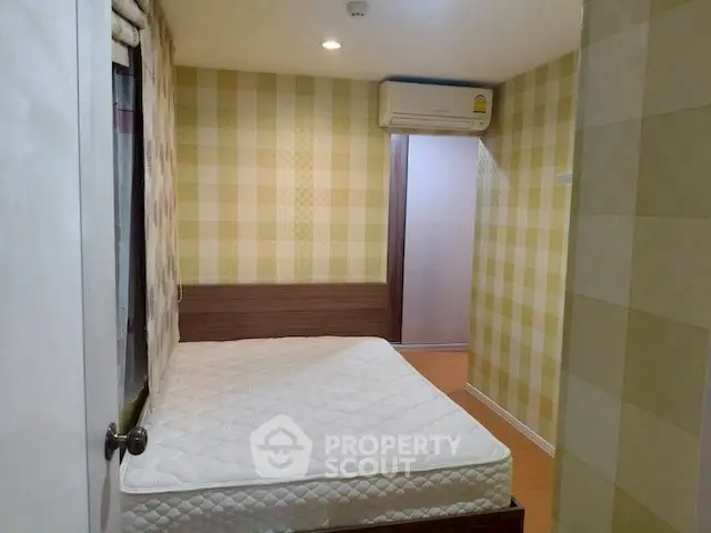 Cozy bedroom with checkered wallpaper and air conditioning unit.