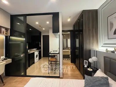 Modern studio apartment with sleek kitchen and cozy bedroom area, featuring stylish decor and efficient layout.