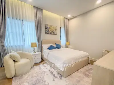 Elegant bedroom with modern decor, featuring a cozy bed, stylish armchair, and soft lighting for a serene ambiance.