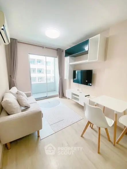 Modern living room with balcony, featuring sleek furniture and natural light.