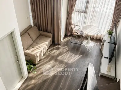 Modern living room with cozy sofa, elegant curtains, and stylish wooden flooring.