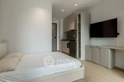 Modern studio apartment with sleek kitchen and cozy bedroom area