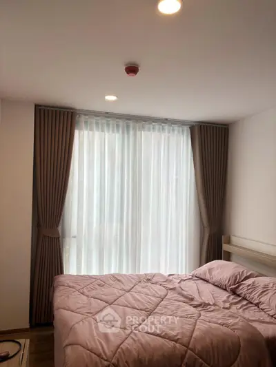 Cozy bedroom with soft lighting and elegant curtains, perfect for relaxation and comfort.