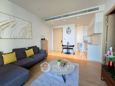 Modern living room with open kitchen, stylish decor, and cozy seating area.