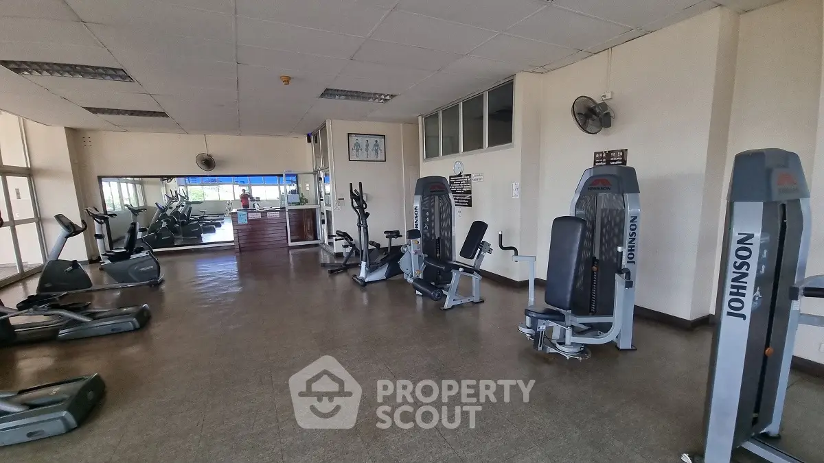 Spacious gym with modern fitness equipment in a well-lit area, ideal for workouts.