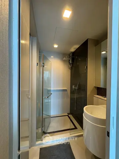 Modern bathroom with glass shower and sleek fixtures in a contemporary apartment.