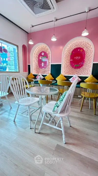 Charming cafe interior with pink accents, cozy seating, and stylish decor.