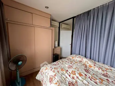 Cozy bedroom with floral bedding and ample closet space in modern apartment.
