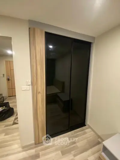 Modern bedroom with sliding glass door and wooden flooring