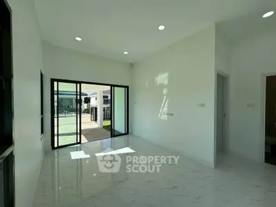 Spacious modern living room with large sliding glass doors and marble flooring