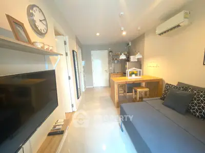 Modern living room with open kitchen, stylish decor, and cozy seating area.
