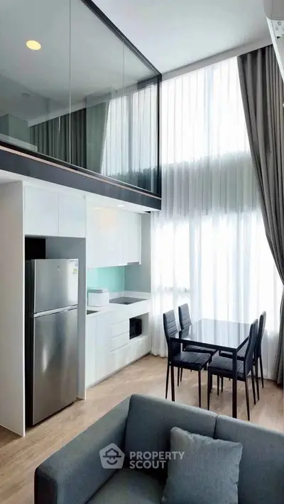 Modern loft apartment with high ceilings, sleek kitchen, and stylish dining area.