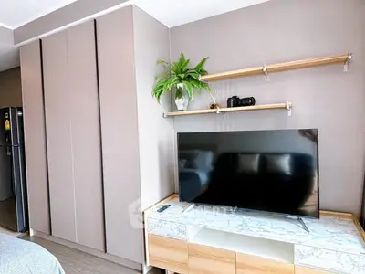 Modern living room with sleek TV stand, wall-mounted shelves, and built-in storage cabinets.