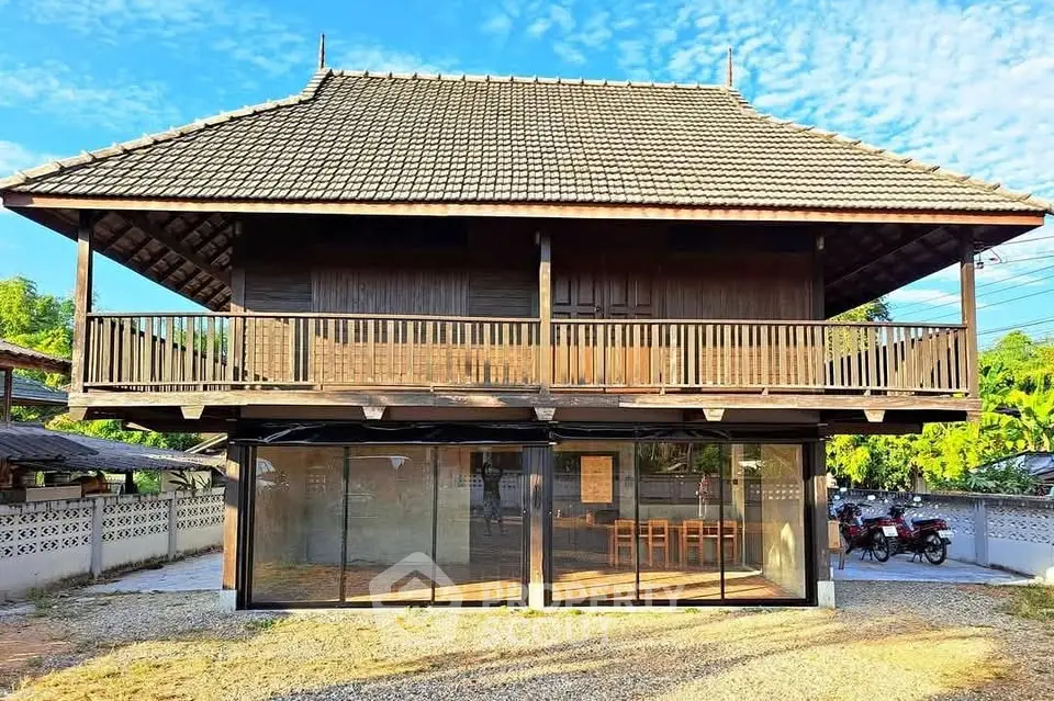 Charming traditional wooden house with spacious balcony and modern glass facade.