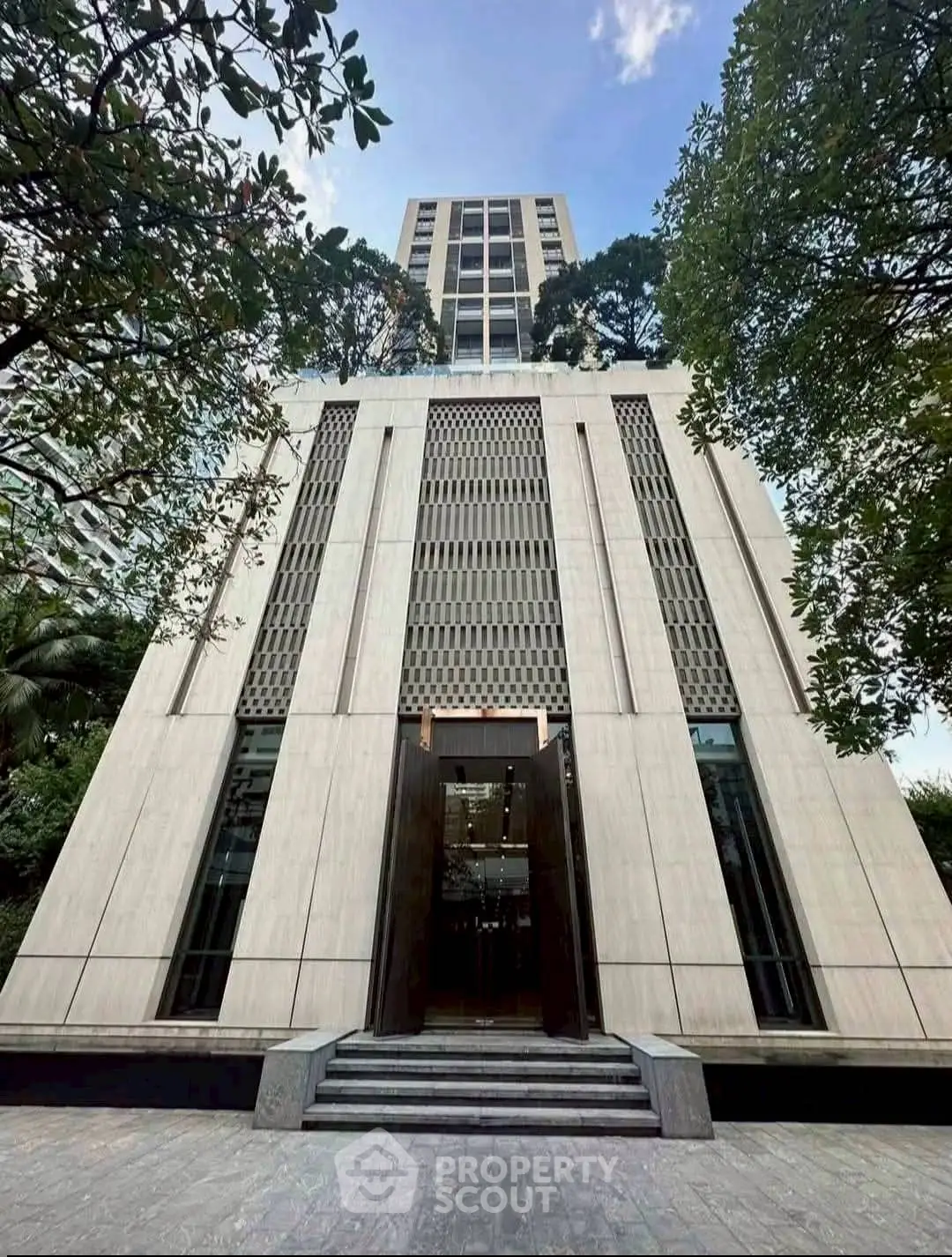 Stunning modern building exterior with elegant entrance and lush greenery.