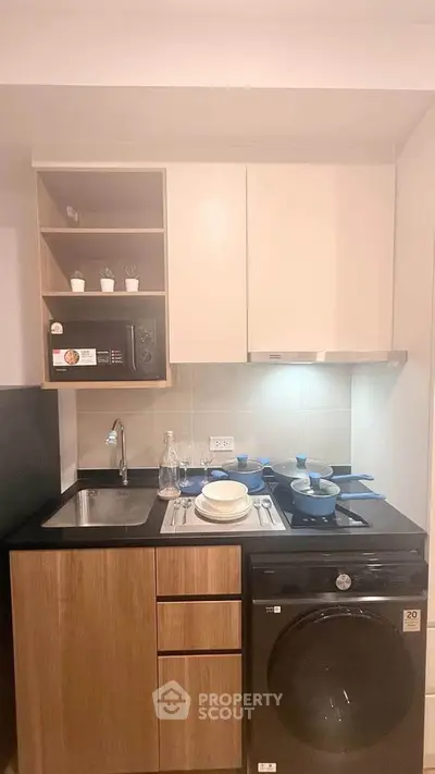 Compact modern kitchen with sleek cabinetry and built-in appliances, perfect for urban living.