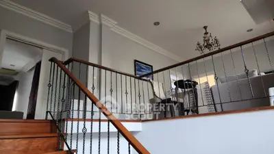 Elegant staircase leading to a stylish living area with chandelier and modern decor