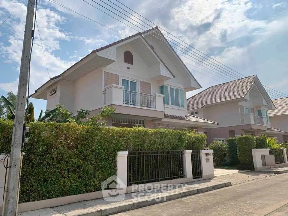 Charming two-story house with lush greenery and modern design in a serene neighborhood.