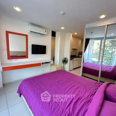 Modern bedroom with vibrant decor and mirrored closet in a stylish apartment.