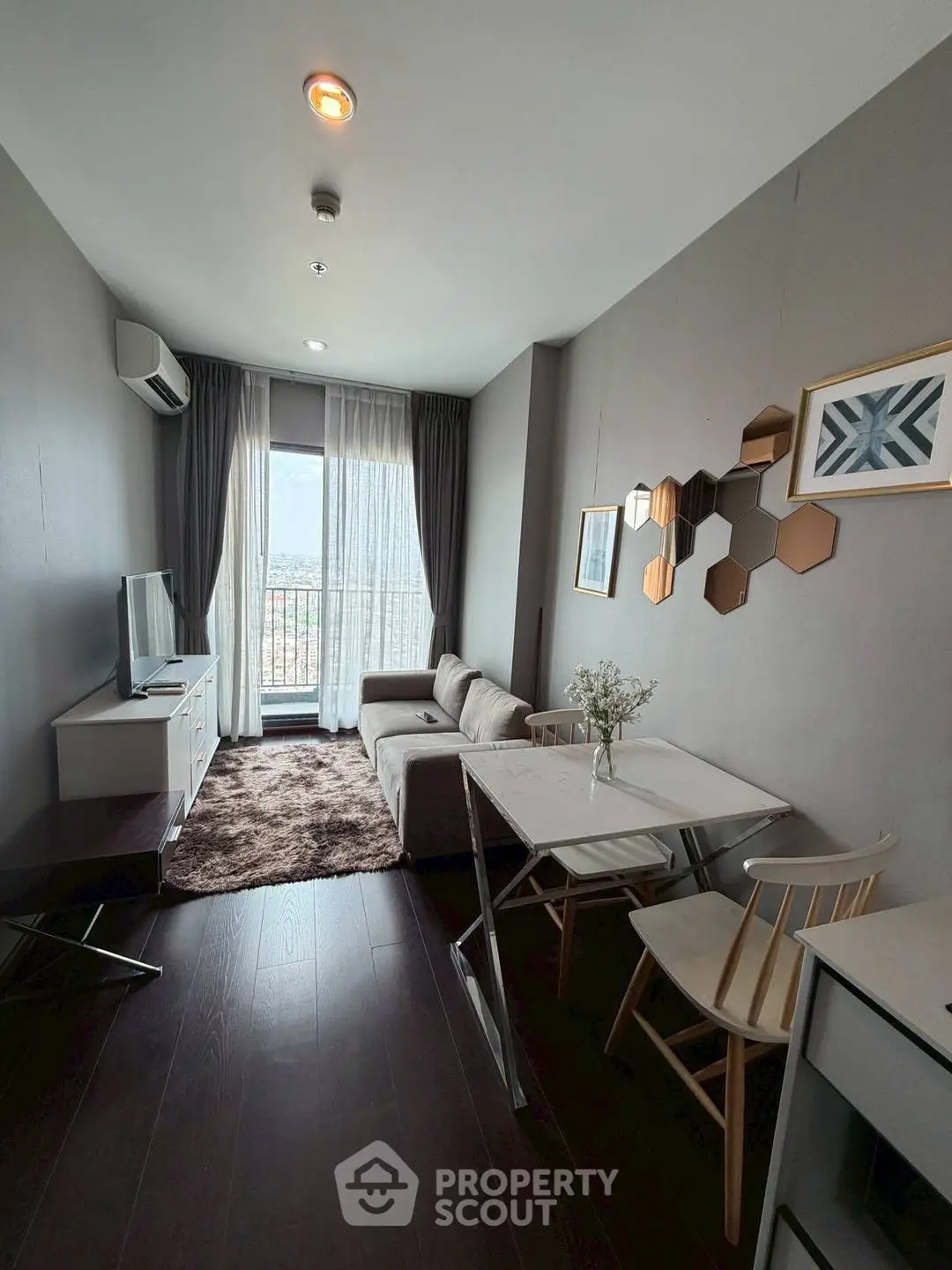 Modern living room with stylish decor and balcony view in a cozy apartment.