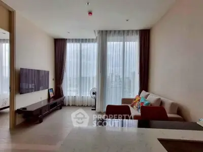 Spacious modern living room with large windows and city view, featuring elegant decor and comfortable seating.