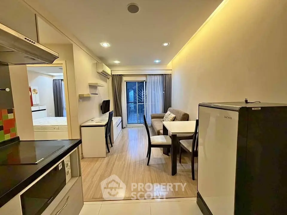 Modern open-plan living room with kitchen and dining area, featuring sleek design and cozy ambiance.