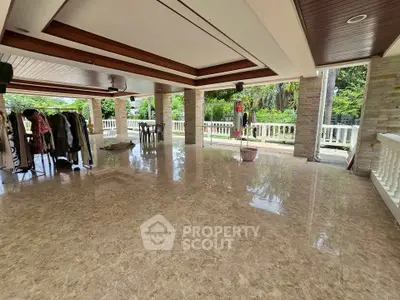 Spacious open-air terrace with marble flooring and lush garden views, perfect for outdoor gatherings.