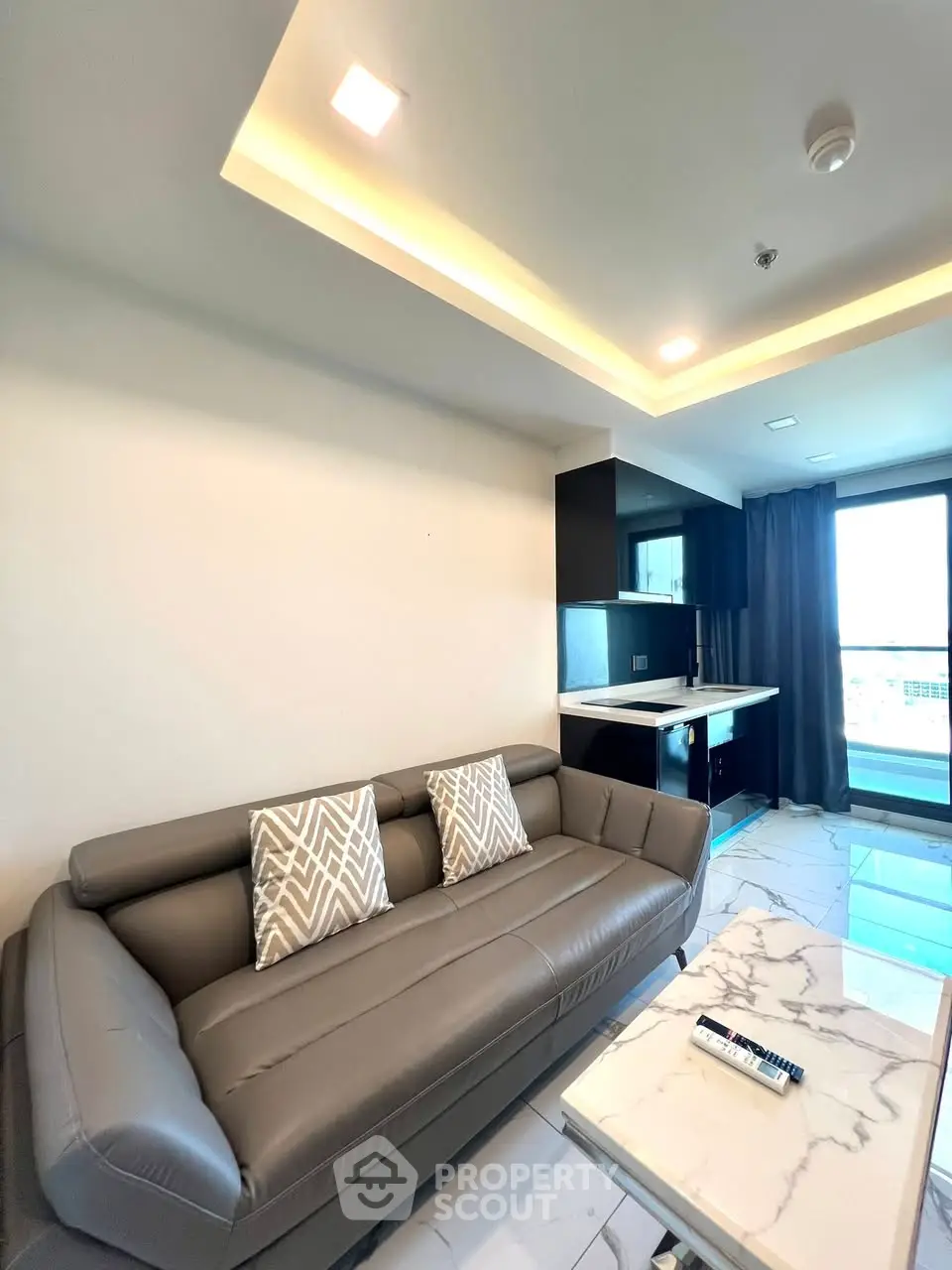Modern living room with sleek sofa and open kitchen layout