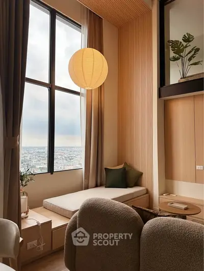 Modern living room with large window and cozy seating area, featuring a serene city view.