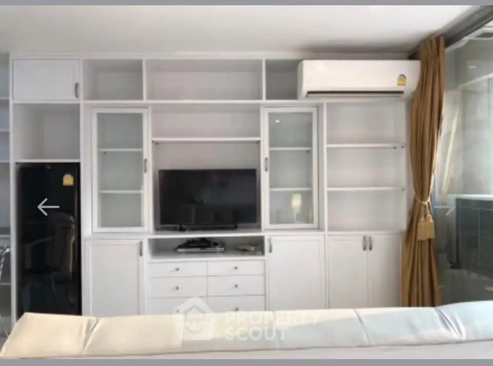 Modern living room with built-in white cabinetry and air conditioning unit