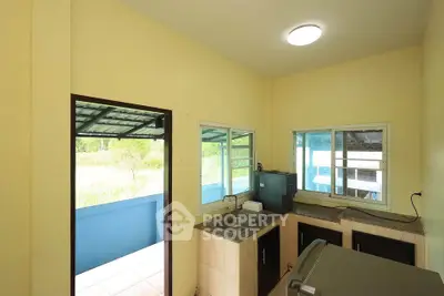 Charming kitchen with open layout and natural light, featuring modern appliances and access to outdoor space.
