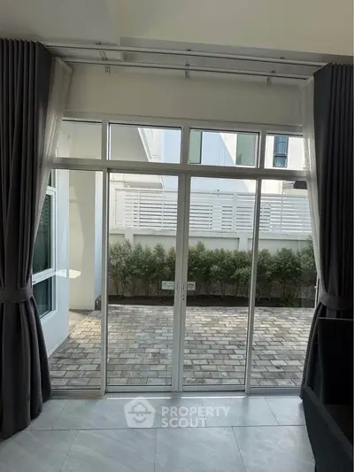 Spacious living room with large glass doors opening to a private patio, perfect for indoor-outdoor living.