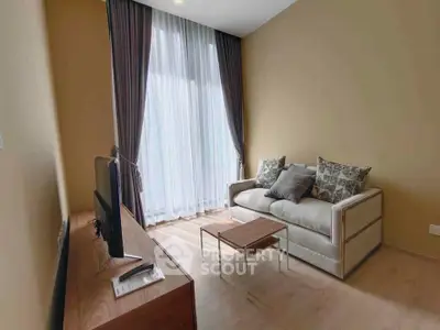 Cozy living room with modern sofa and large window, perfect for relaxation.