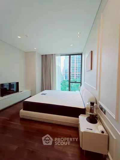 Modern bedroom with large window and city view, featuring sleek furniture and elegant decor.