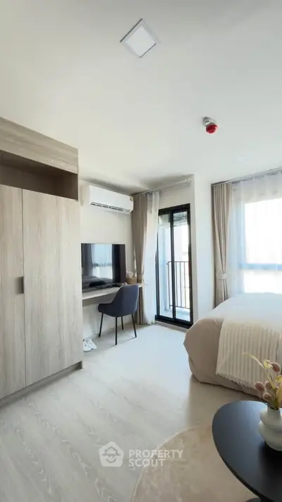 Modern bedroom with study area and balcony access in a stylish apartment