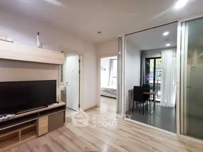 Modern apartment interior with open living room and dining area, featuring sleek wooden flooring and stylish decor.