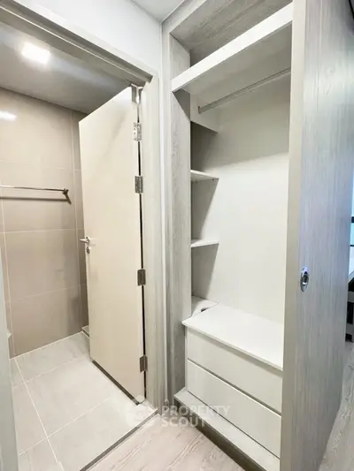 Modern bathroom entrance with sleek closet storage in contemporary apartment