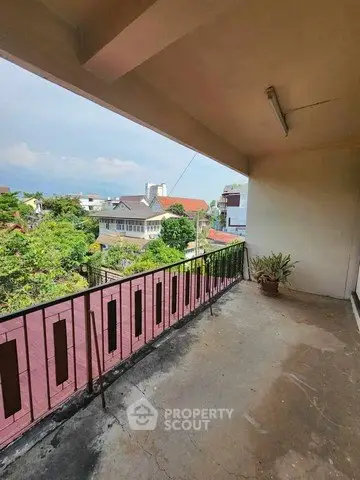 Spacious balcony with scenic view of suburban houses and greenery, perfect for relaxation.