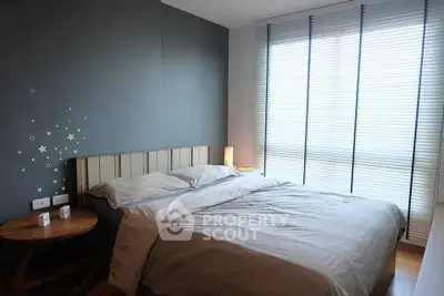 Cozy bedroom with modern decor and ample natural light from large windows.