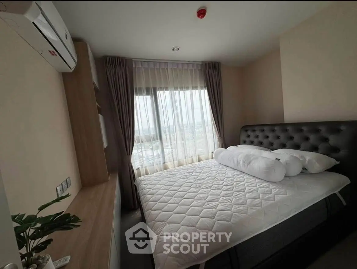 Cozy bedroom with large window and modern furnishings, offering a serene and inviting atmosphere.