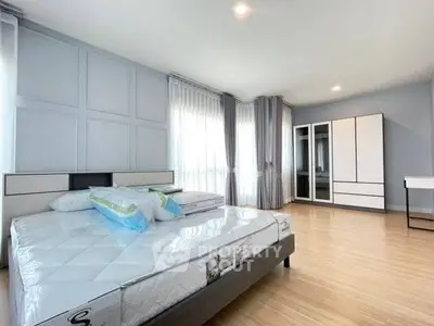 Spacious modern bedroom with large windows and stylish furniture