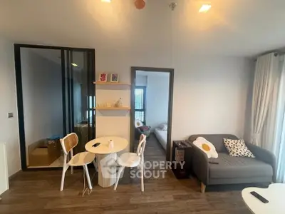Modern living room with cozy seating and dining area, featuring stylish decor and natural light.