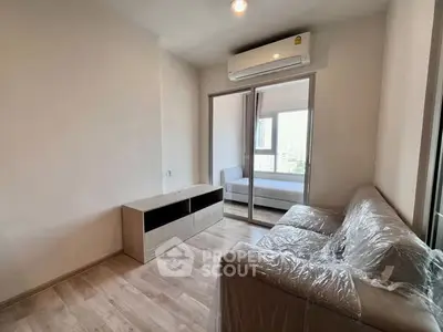 Modern living room with air conditioning and sliding glass doors to bedroom