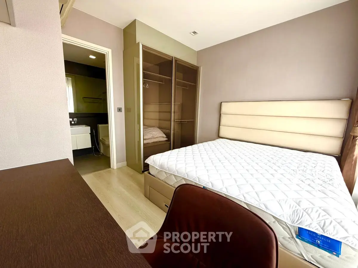Modern bedroom with ensuite bathroom and stylish furniture in a contemporary apartment.