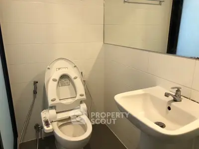 Modern bathroom with sleek fixtures and a smart toilet in a contemporary apartment.
