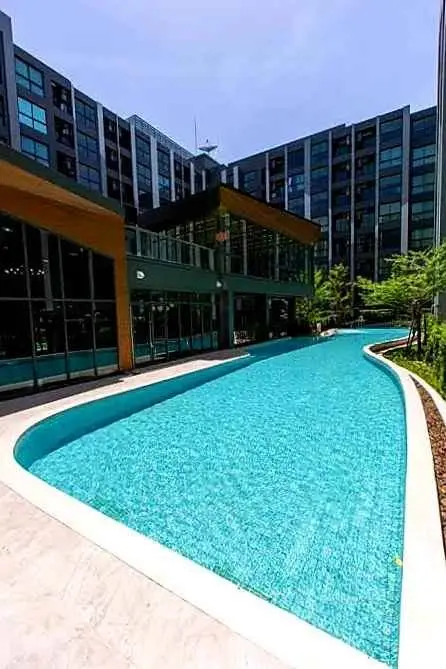 Luxurious modern apartment complex with a stunning outdoor pool and sleek architectural design.