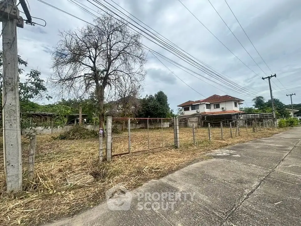 Spacious plot of land with a charming house and fenced boundary, ideal for development.