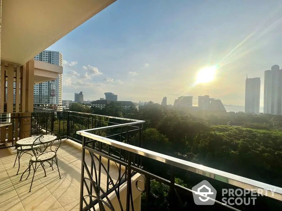 Stunning balcony view with city skyline and lush greenery at sunset.